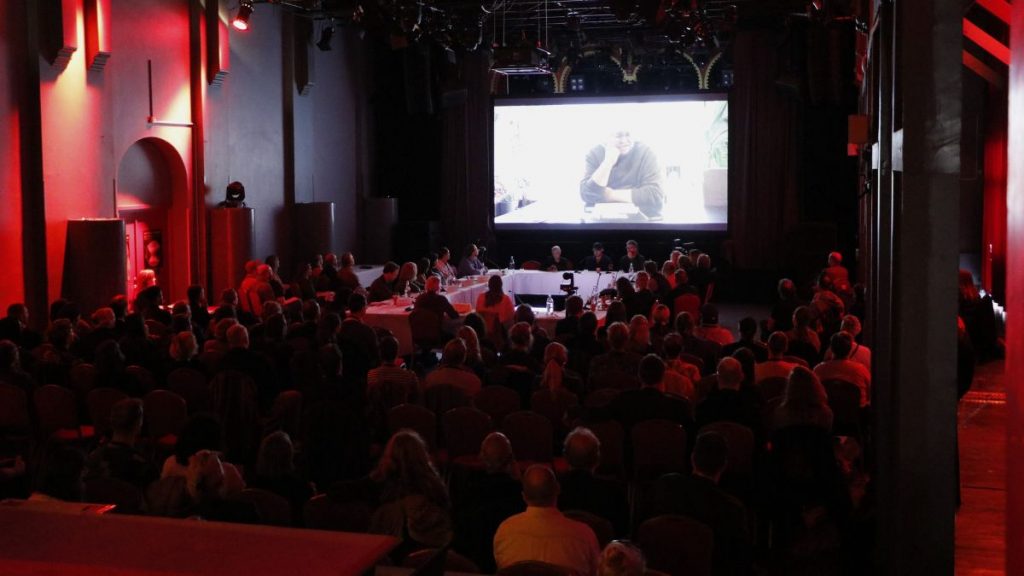 A room of people watching a cinema screen